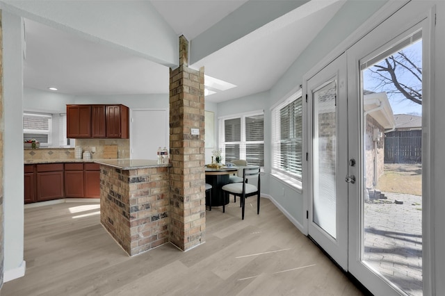 kitchen with baseboards, ornate columns, recessed lighting, decorative backsplash, and light wood-style floors