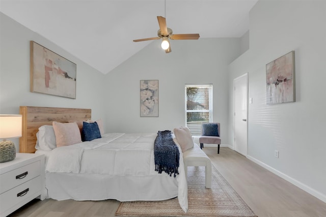 bedroom featuring light wood-type flooring, baseboards, high vaulted ceiling, and a ceiling fan