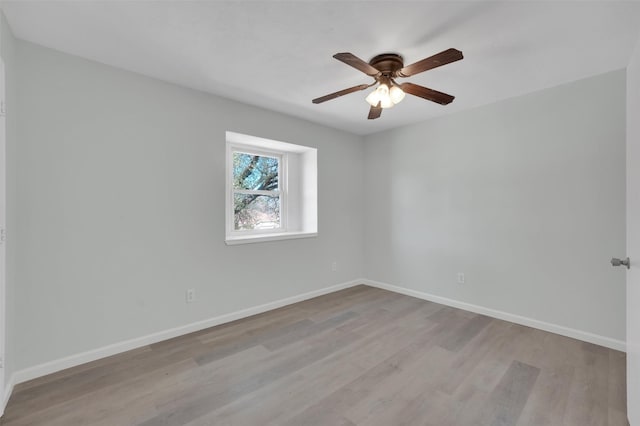 empty room featuring a ceiling fan, wood finished floors, and baseboards