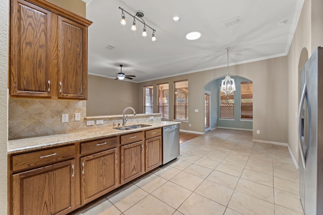 kitchen with light tile patterned floors, appliances with stainless steel finishes, crown molding, and a sink