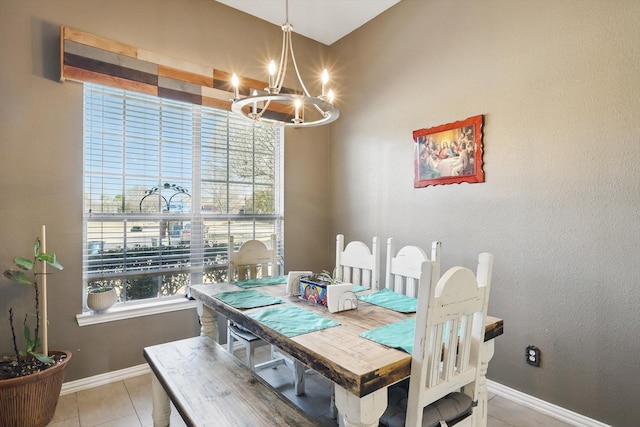 dining area featuring light tile patterned floors, baseboards, and a notable chandelier