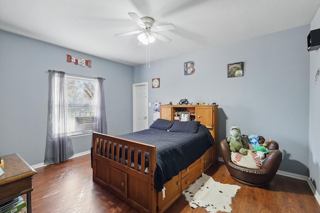 bedroom with baseboards, wood finished floors, and a ceiling fan