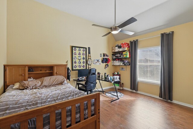 bedroom featuring baseboards, a ceiling fan, lofted ceiling, and wood finished floors