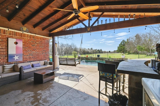 view of patio / terrace with a fenced in pool, ceiling fan, an outdoor hangout area, outdoor wet bar, and a fenced backyard