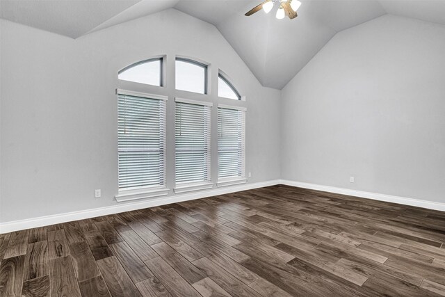 unfurnished room featuring lofted ceiling, a ceiling fan, dark wood-style flooring, and baseboards