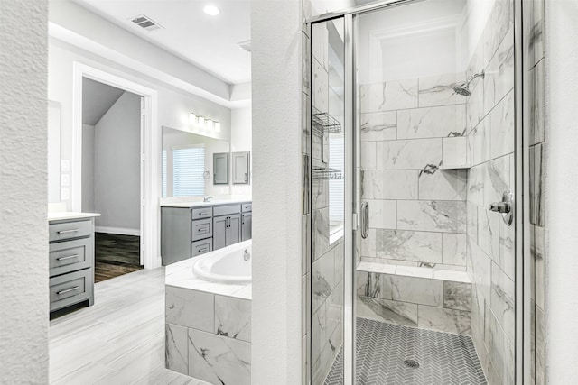 full bathroom with a bath, visible vents, a stall shower, and vanity