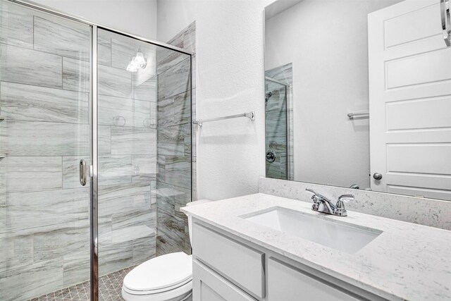 full bathroom featuring vanity, toilet, and a stall shower