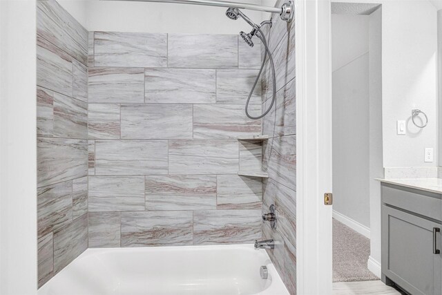 bathroom featuring vanity,  shower combination, and baseboards