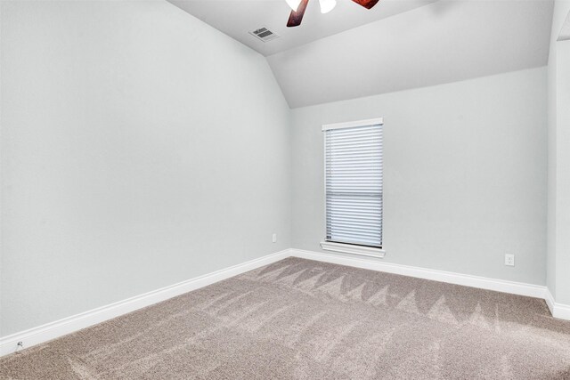 spare room with visible vents, baseboards, lofted ceiling, carpet flooring, and a ceiling fan