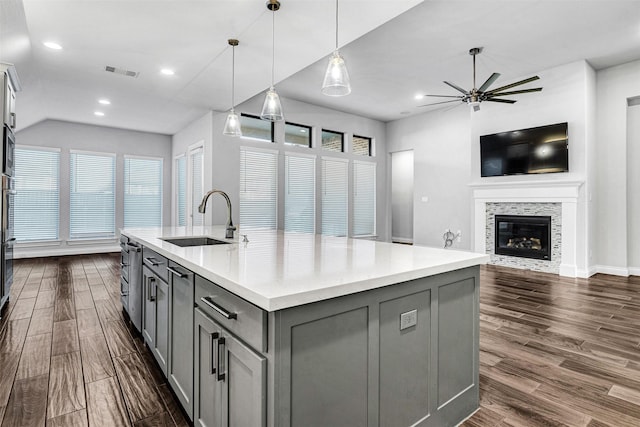 kitchen with visible vents, a sink, a tile fireplace, dark wood-type flooring, and gray cabinetry