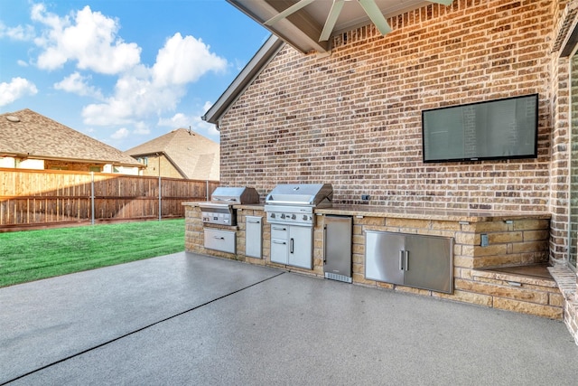 view of patio / terrace with grilling area, an outdoor kitchen, and fence