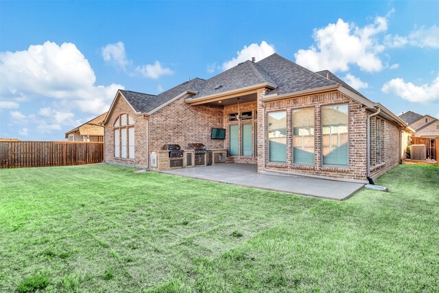 back of property with area for grilling, a fenced backyard, a lawn, a patio area, and brick siding