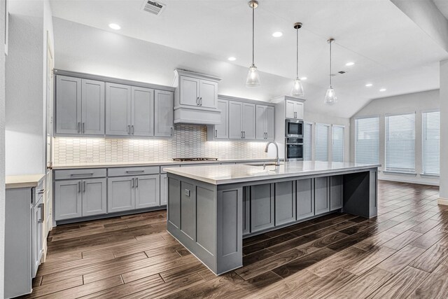 kitchen featuring a sink, premium range hood, dark wood-style flooring, and gray cabinetry