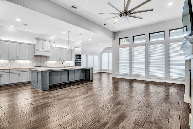 kitchen with visible vents, backsplash, dark wood-style floors, open floor plan, and stainless steel appliances