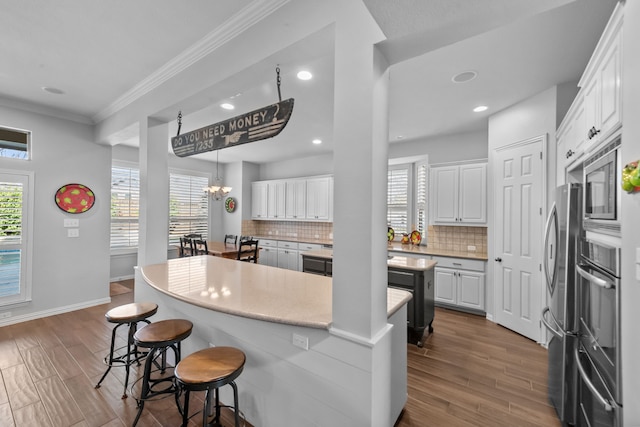 kitchen with backsplash, a breakfast bar area, a center island, and white cabinetry