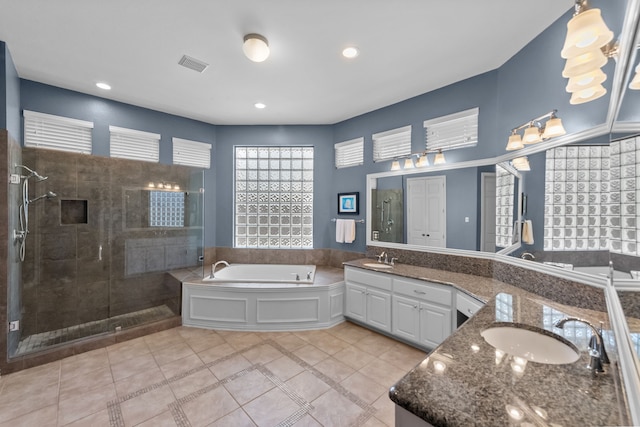 full bath featuring double vanity, visible vents, a stall shower, and a sink