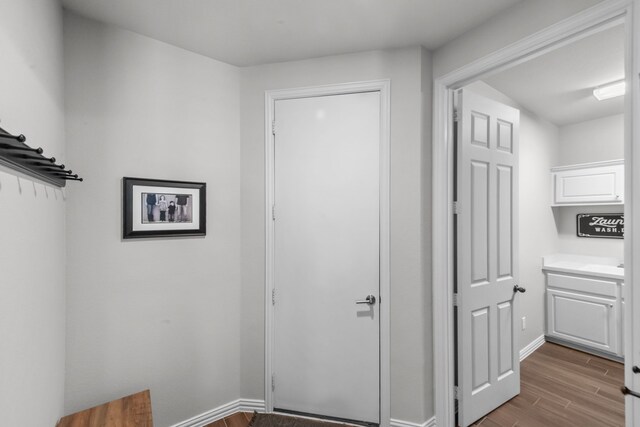 interior space with baseboards and wood finished floors