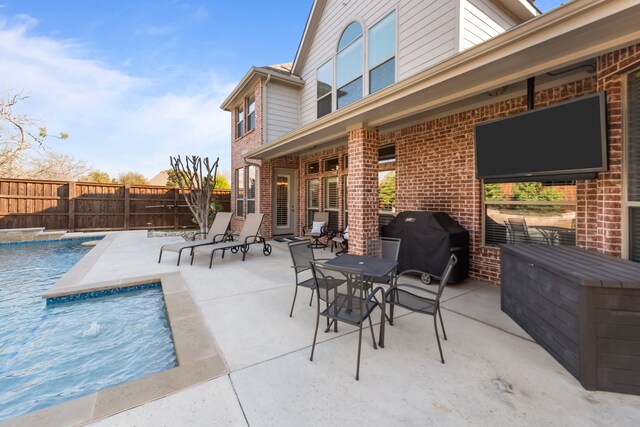 view of patio / terrace with fence, a fenced in pool, and a grill