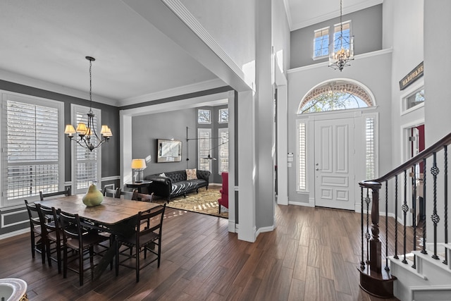 entryway featuring stairway, baseboards, dark wood finished floors, ornamental molding, and a chandelier