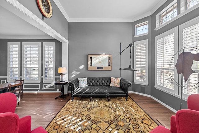 living room with plenty of natural light, wood finished floors, baseboards, and ornamental molding