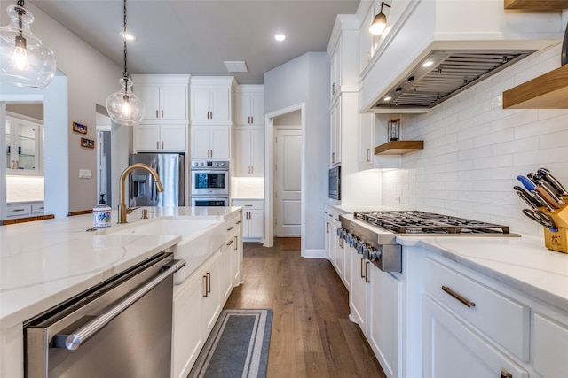 kitchen featuring white cabinets, appliances with stainless steel finishes, and custom range hood