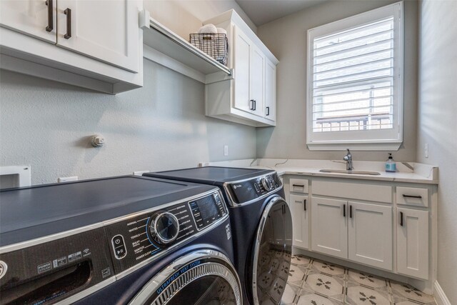 laundry area featuring a sink, cabinet space, and washing machine and dryer