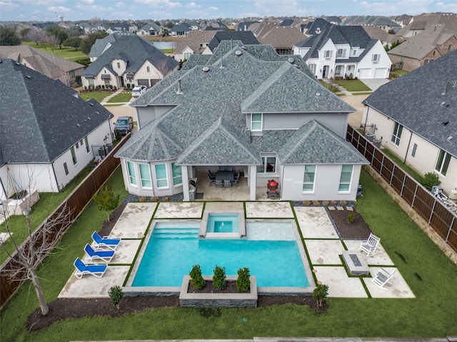 view of swimming pool with a yard, a residential view, a patio, and a fenced backyard