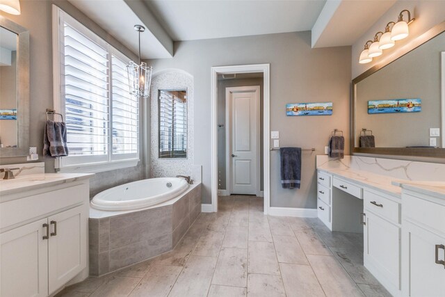 full bath featuring a sink, two vanities, and a bath