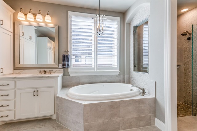 bathroom with tile patterned flooring, a garden tub, vanity, and a walk in shower