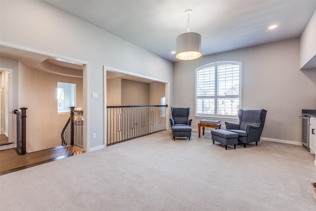 sitting room with light carpet, an upstairs landing, recessed lighting, and baseboards