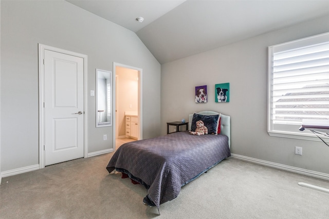 carpeted bedroom featuring ensuite bath, vaulted ceiling, and baseboards