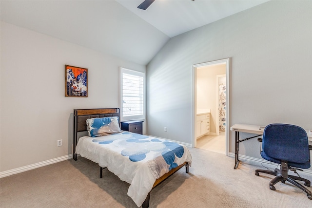 carpeted bedroom featuring baseboards, lofted ceiling, ensuite bath, and a ceiling fan