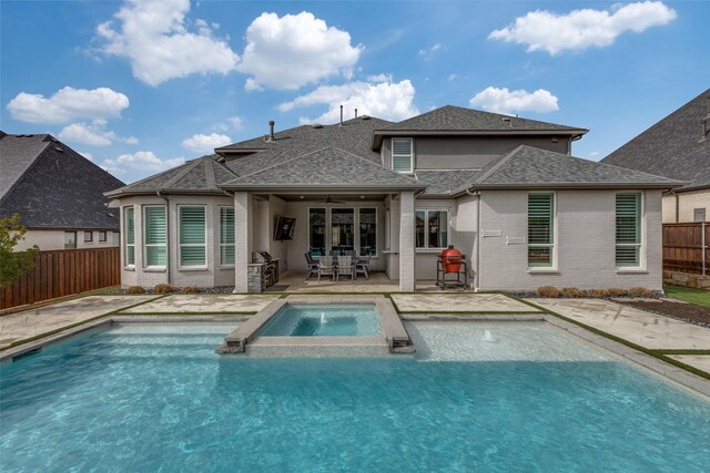 rear view of house with brick siding, a pool with connected hot tub, a shingled roof, a fenced backyard, and a patio