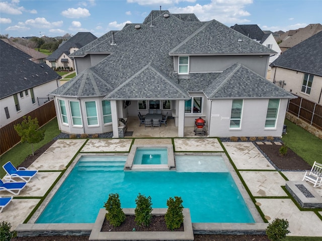 rear view of property with a patio area, a fenced backyard, stucco siding, and roof with shingles