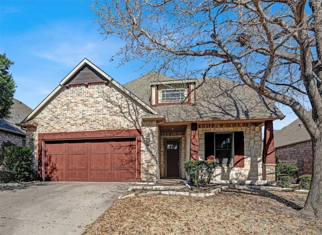 view of front facade with an attached garage, stone siding, driveway, and roof with shingles