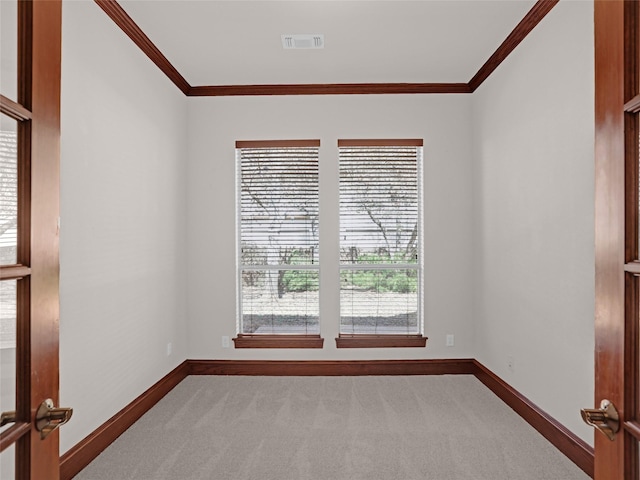 carpeted empty room with visible vents, baseboards, and ornamental molding