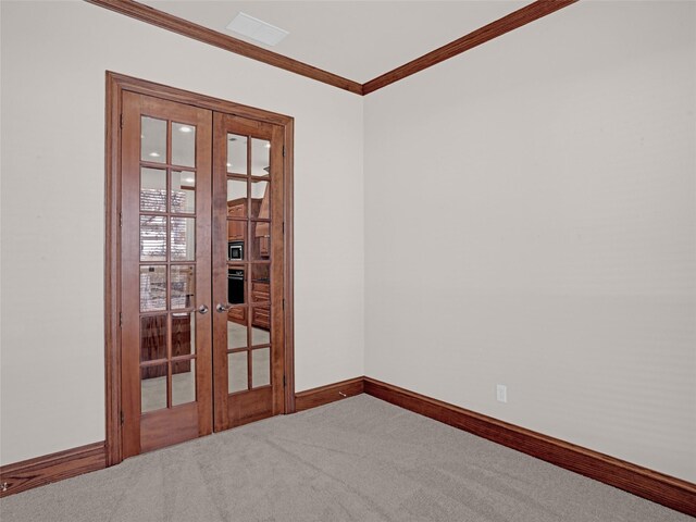 empty room with carpet flooring, french doors, baseboards, and ornamental molding