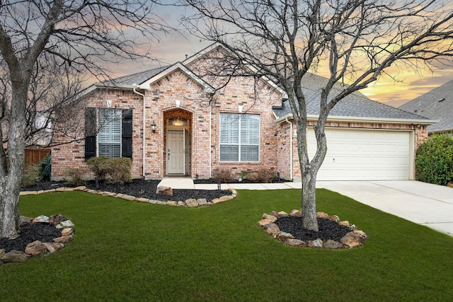 traditional home featuring brick siding, concrete driveway, a front yard, and a garage