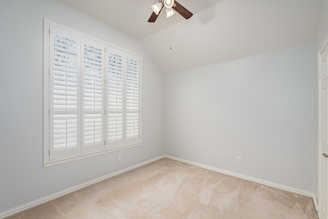 carpeted empty room with baseboards, lofted ceiling, and a ceiling fan