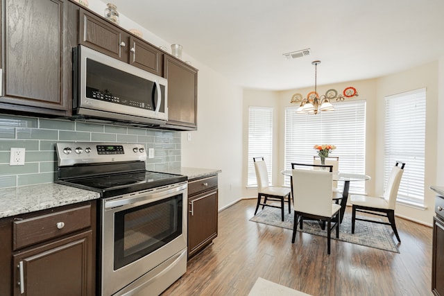 kitchen featuring visible vents, a healthy amount of sunlight, dark brown cabinetry, dark wood-style floors, and stainless steel appliances