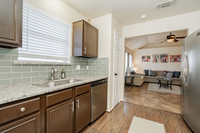 kitchen with visible vents, a ceiling fan, a sink, backsplash, and appliances with stainless steel finishes