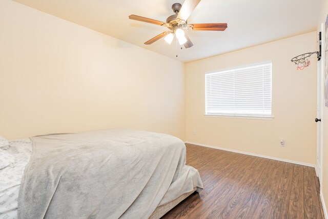 bedroom featuring a ceiling fan, wood finished floors, and baseboards