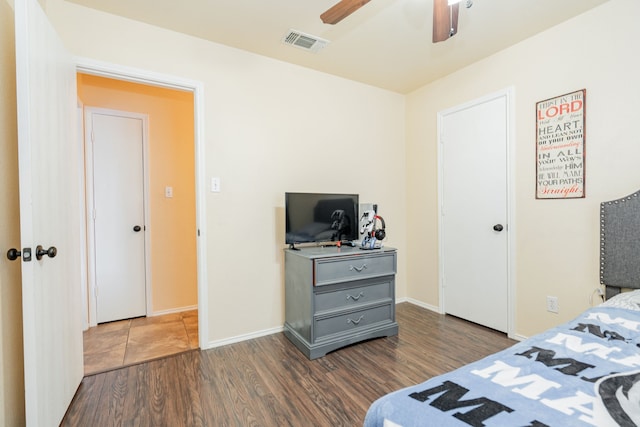 bedroom with visible vents, ceiling fan, baseboards, and wood finished floors