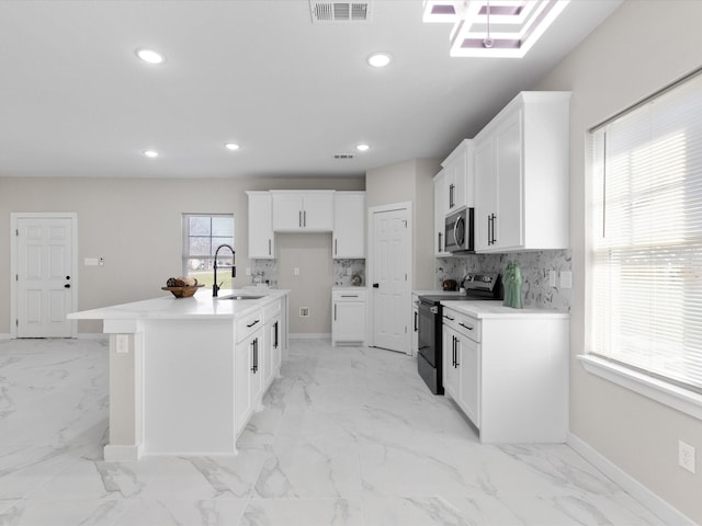 kitchen with marble finish floor, range with electric stovetop, visible vents, a sink, and stainless steel microwave