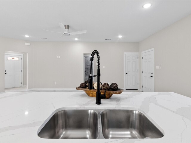 room details featuring recessed lighting, visible vents, light stone counters, and a sink