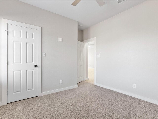 spare room with visible vents, a ceiling fan, baseboards, and carpet floors
