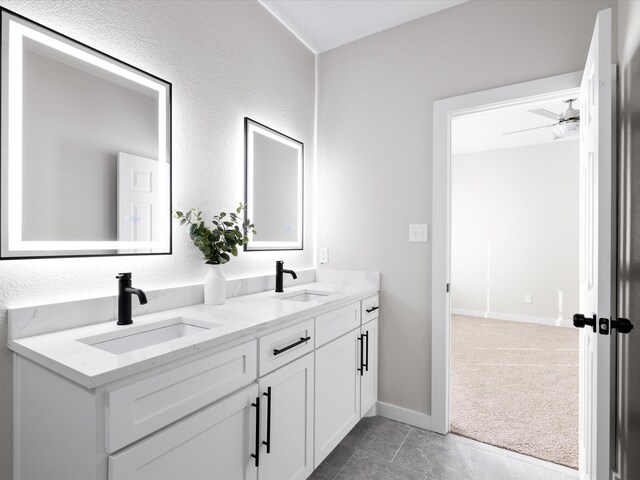 bathroom with double vanity, tile patterned flooring, baseboards, and a sink
