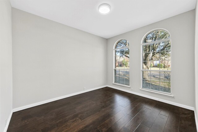 empty room with baseboards and dark wood-style flooring