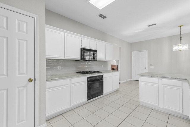 kitchen with tasteful backsplash, visible vents, white cabinetry, and black appliances