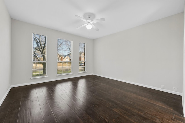 unfurnished room with baseboards, dark wood finished floors, and a ceiling fan